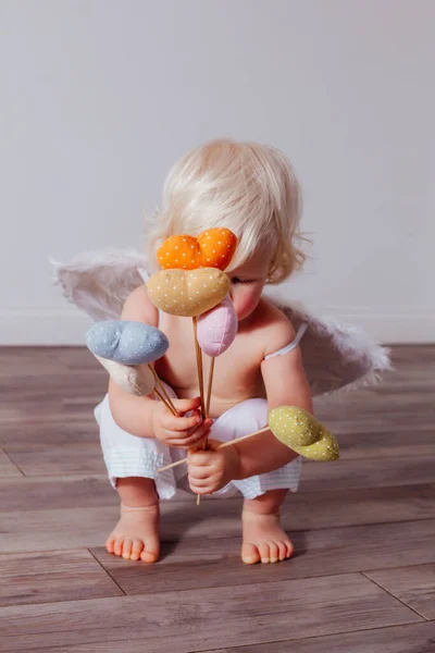 Handmade textile hearts in the hands of little Cupid — Stock Photo, Image