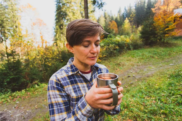 Kadın bir fincan çayla sonbahar parkında. — Stok fotoğraf