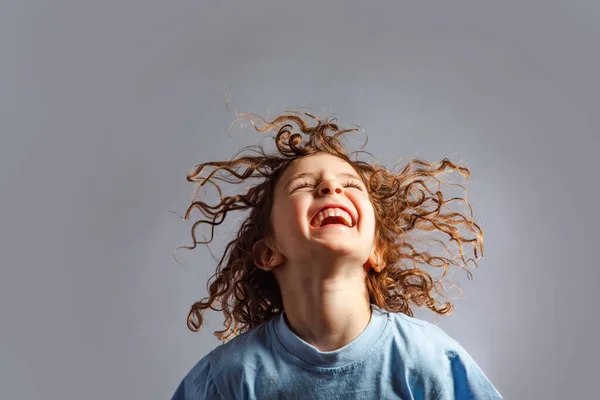 Kleines Mädchen springt auf grauen Hintergrund — Stockfoto