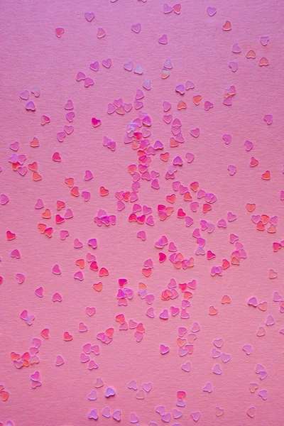 Scattering pink small hearts on a pink background — Stock Photo, Image