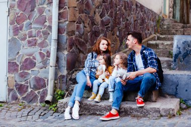 Genç aile, eski şehirde yürürken dinleniyor.