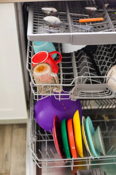 Положить грязные тарелки в посудомоечную машину после ужина — стоковое фото