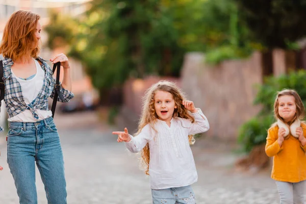 La maman avec des filles à la recherche d'un moyen tout en voyageant — Photo