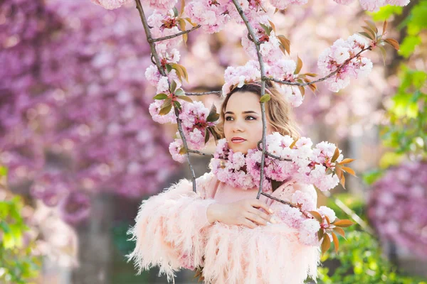 Das Mädchen steht unter dem rosa Baum, der blüht — Stockfoto