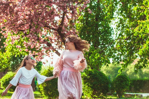 母と娘は柔らかい植物の隣に立っています — ストック写真