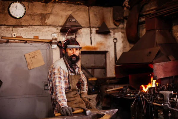 Barbudo herrero después de trabajar en su taller. taller de herreros. — Foto de Stock