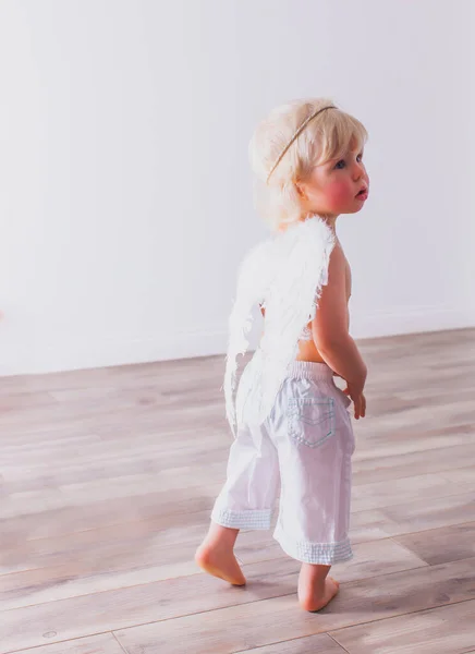 The cute baby is wearing a cupid costume in the room — Stock Photo, Image