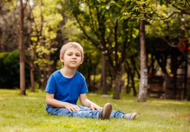 Yalnız küçük çocuk arka bahçede oturuyor.