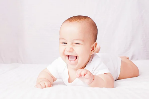 Liebenswertes Baby auf dem Bauch liegend am weißen — Stockfoto