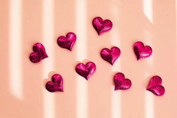 Red sparkle hearts scattered on the beige background — Stock Photo, Image