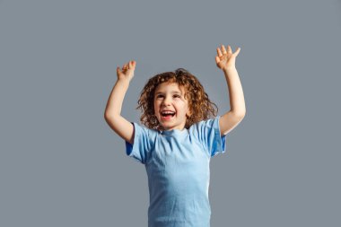 Küçük kız gri arka planda zıplıyor