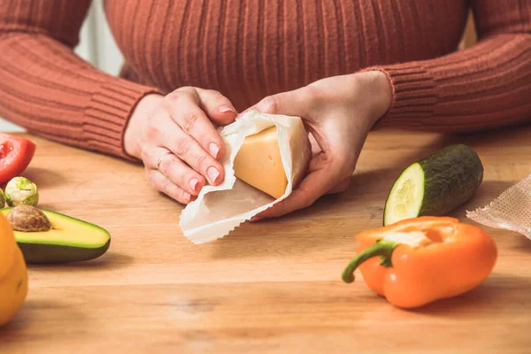 Femmina avvolgendo formaggio in impacchi di cera d'api in cucina — Foto Stock