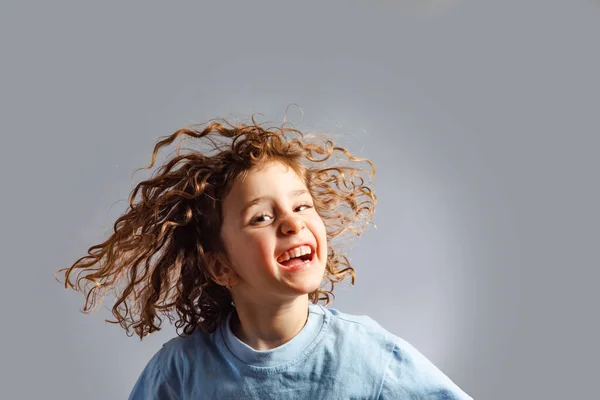 Menina salta em um fundo cinza — Fotografia de Stock