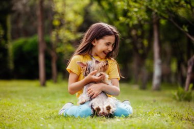 Evcil hayvanı olan mutlu kız dışarıda rahatlar.