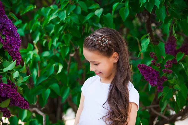 Die Frau um einen blühenden lila Flieder im Garten — Stockfoto