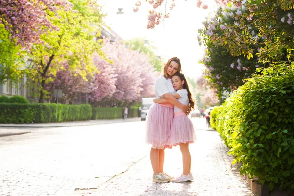 Mom and daughter are standing next to a tender plant — Stock Photo, Image