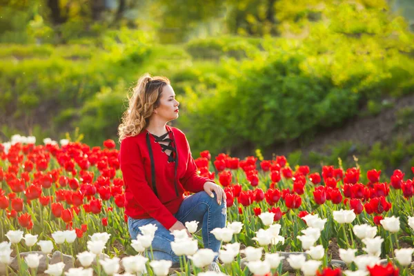 Frau inmitten eines Feldes aus roten und weißen Tulpen — Stockfoto