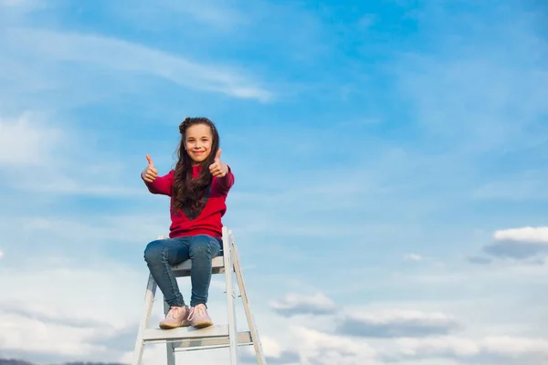 Merdivenin tepesindeki kız gökyüzüne karşı — Stok fotoğraf