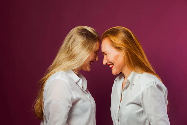 Duas mulheres em pé em frente uma da outra, tocando pela cabeça — Fotografia de Stock