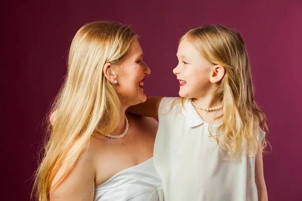 Retrato de madre e hija aisladas sobre fondo púrpura — Foto de Stock