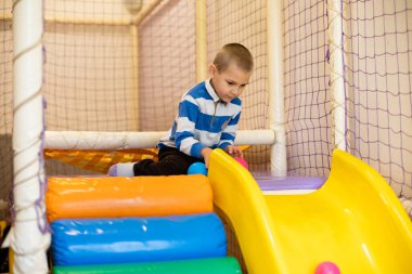 Kapalı oyun merkezinde gülümseyen bebek.