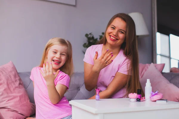 the happy mom and daughter are engaged in beauty together