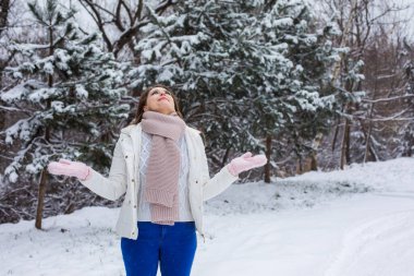 Kadın kış parkında yürümekten hoşlanıyor.
