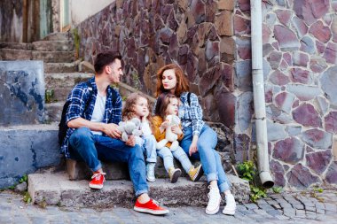 Genç aile, eski şehirde yürürken dinleniyor.