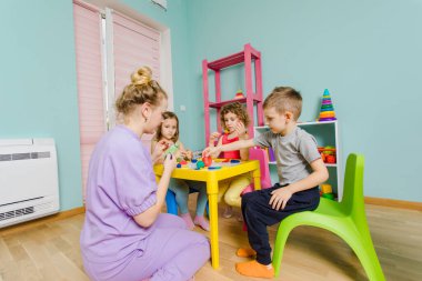 Çocuk anaokulundaki işinden zevk alıyor.