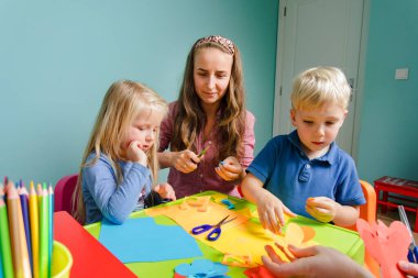 Çocuklar ve öğretmenler kreatif okulda birlikte okuyorlar.