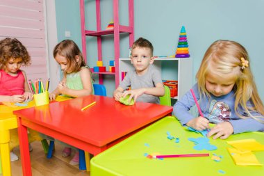 Çocuklar anaokulunda birlikte parlak şeyler yaratıyorlar.