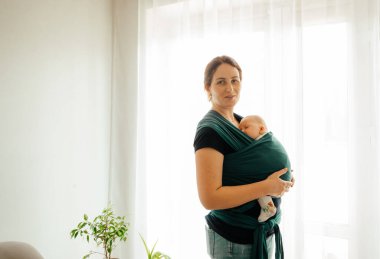 Bebek taşıyıcısında uyuyan mutlu bir anne