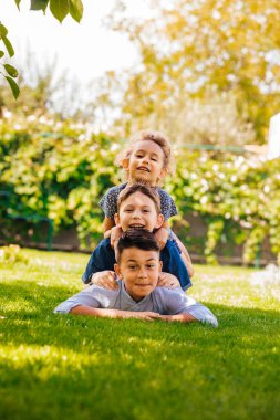 Üç küçük çocuğun bir kule gibi portresi