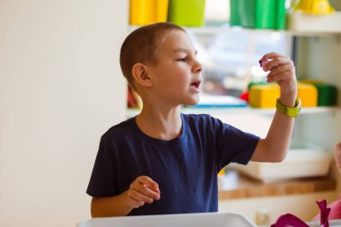 Anaokulu öğrencisi gerekli oyuncak detaylarını arıyor.