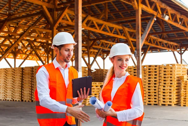 Young engineer woman and her subordinate worker at the factory