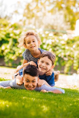 Üç küçük çocuğun bir kule gibi portresi