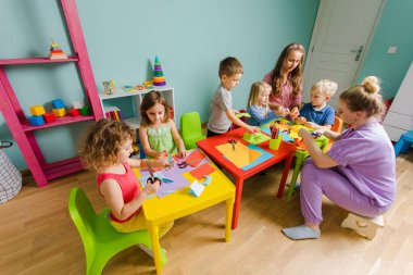 Çocuklar ve öğretmenler kreatif okulda birlikte okuyorlar.