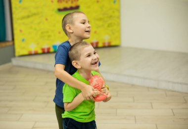 İki neşeli küçük kardeş yumuşak oyuncaklarla oynuyor.