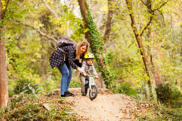 Mamá de apoyo anima al niño a montar por la colina — Foto de Stock
