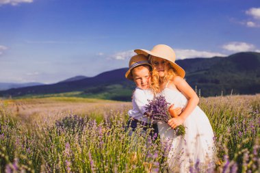 İki sevimli çocuk, kız ve erkek, birlikte duruyorlar.