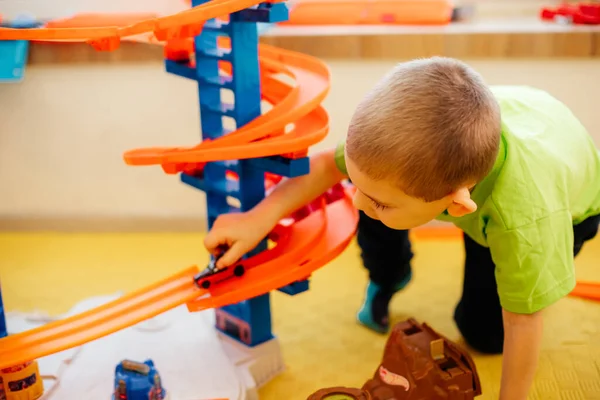 Tatlı çocuk evde oyuncak arabalarla oynuyor.