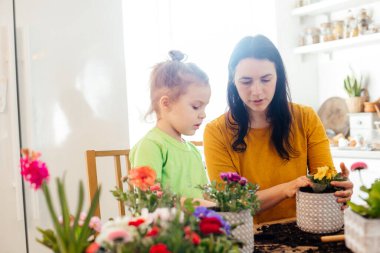 Küçük yardımcı eve çiçek ekerken anneye yardım ediyor.