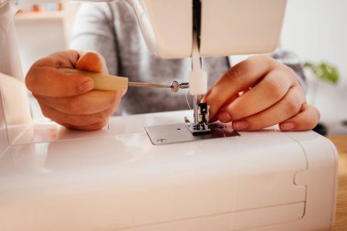 Profesyonel terzi modern dikiş makinesini tamir edebilir.