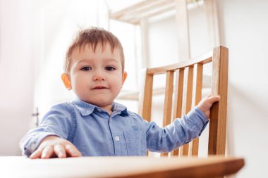 Şirin çocuk masada oturuyor.