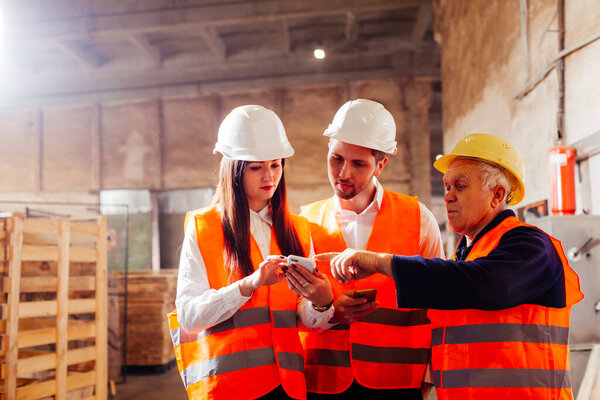 Group of engineers and workers discuss production plans