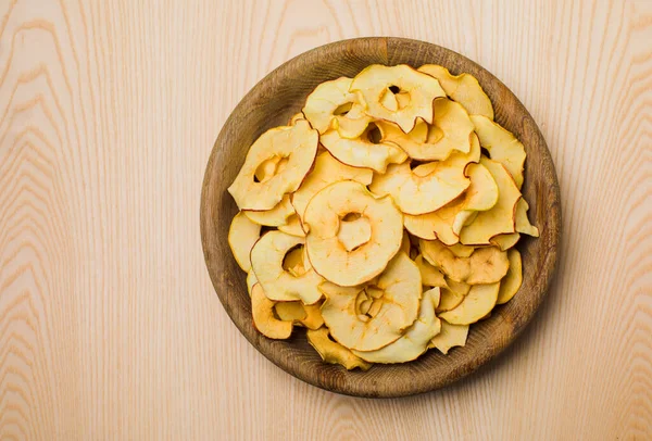 Wooden bowl of round dried slices of apple — Stock Photo, Image