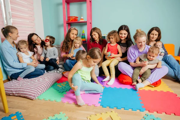 Lovely preschool girl at a meeting of mothers with kids — Stock Photo, Image