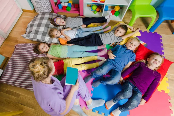 幼稚園で柔らかい枕とマットに寝そべっているアクティブな子供たち — ストック写真