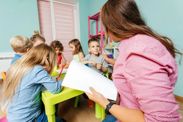 Дошкольник требует внимания учителей во время урока рисования — стоковое фото