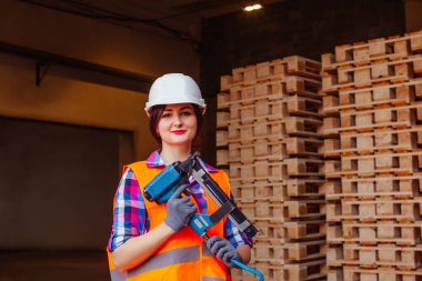 Ahşap fabrikasında çalışan kadın marangoz, elinde profesyonel aletler var..